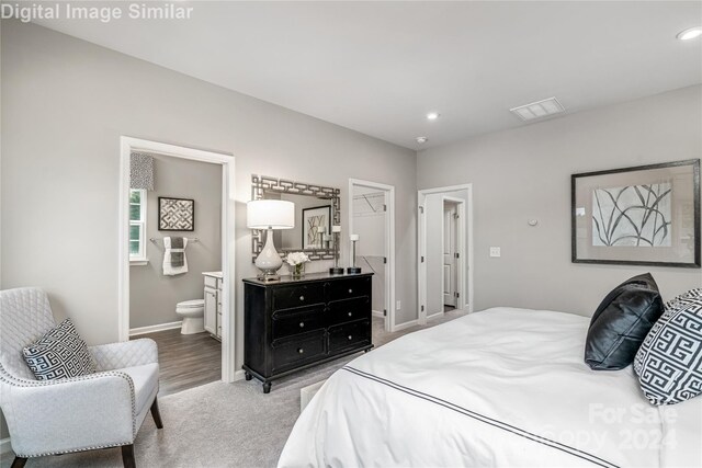 carpeted bedroom featuring recessed lighting, connected bathroom, baseboards, and visible vents