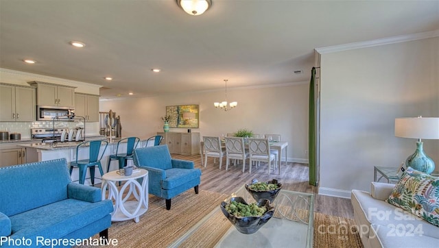 living room featuring an inviting chandelier, crown molding, and light hardwood / wood-style flooring