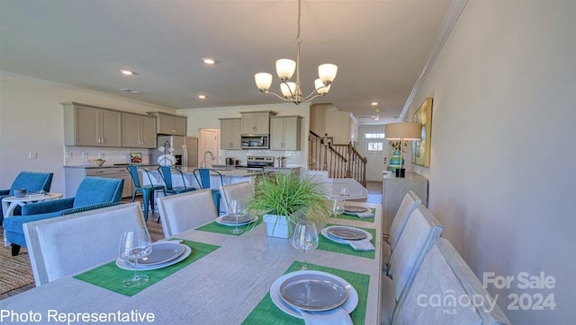 dining area featuring sink, a chandelier, and ornamental molding