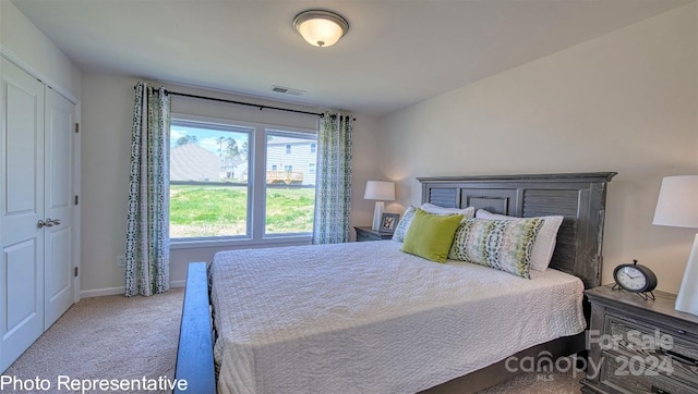 bedroom with light colored carpet and a closet