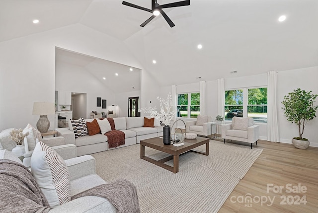 living room with high vaulted ceiling, light hardwood / wood-style flooring, and ceiling fan