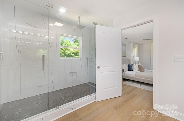 bathroom featuring a shower with shower door and hardwood / wood-style flooring