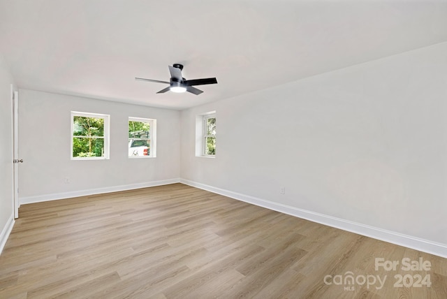 empty room with light hardwood / wood-style floors, plenty of natural light, and ceiling fan