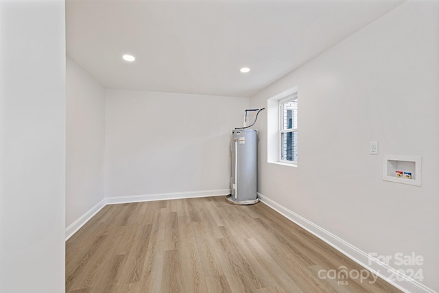 unfurnished room featuring light wood-type flooring and water heater