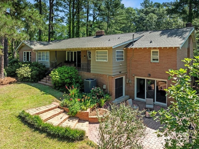 back of house with a lawn, central air condition unit, and a patio area