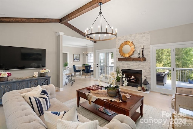 living room featuring french doors, light wood-type flooring, a fireplace, beamed ceiling, and a chandelier