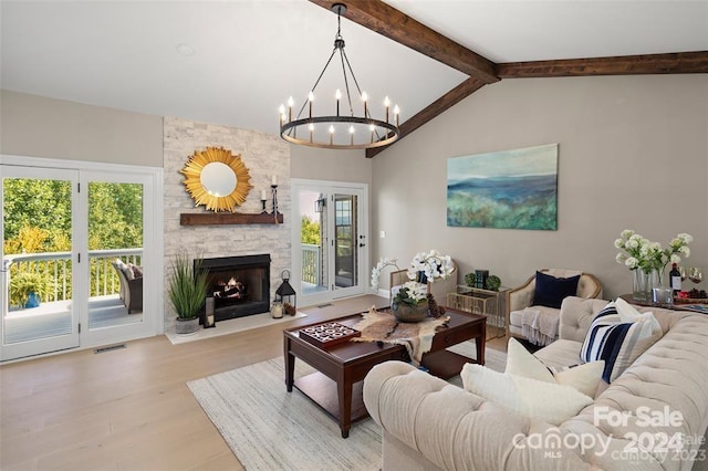 living room with a fireplace, an inviting chandelier, a healthy amount of sunlight, and light hardwood / wood-style floors