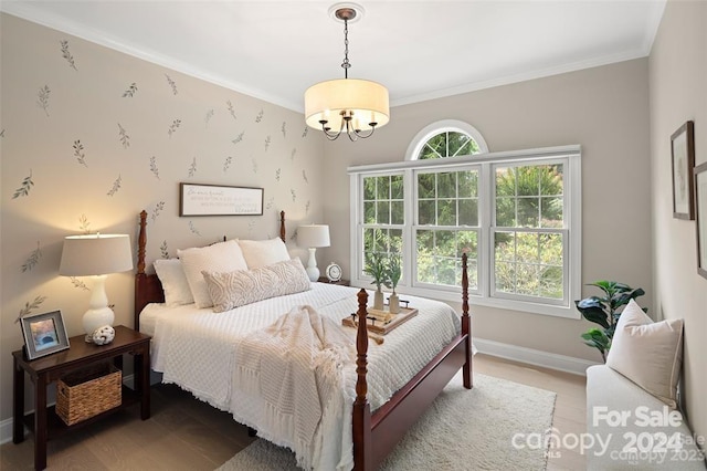 bedroom featuring ornamental molding, a notable chandelier, and hardwood / wood-style floors