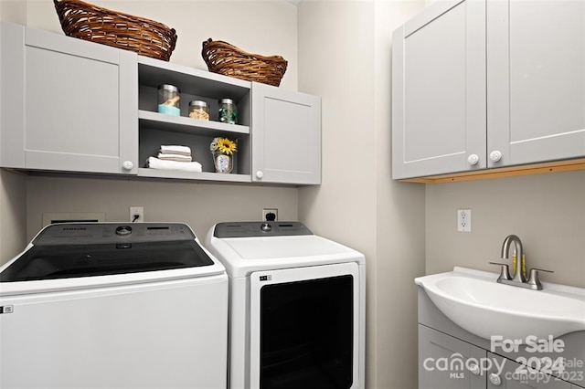 laundry room featuring washing machine and clothes dryer, sink, and cabinets