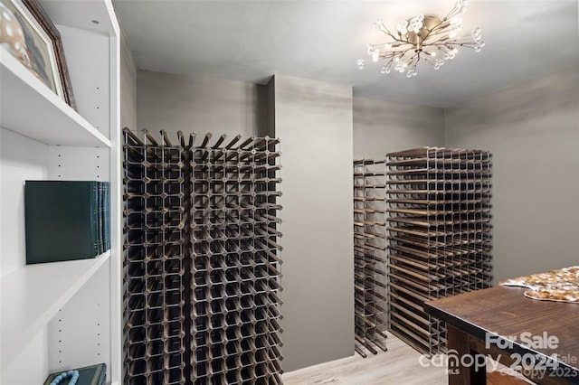 wine room with hardwood / wood-style flooring and a notable chandelier