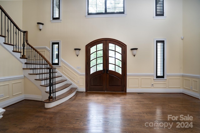 entrance foyer with dark wood-type flooring, a wealth of natural light, and french doors