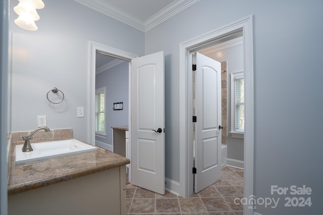 bathroom featuring crown molding, tile patterned flooring, vanity, and a healthy amount of sunlight