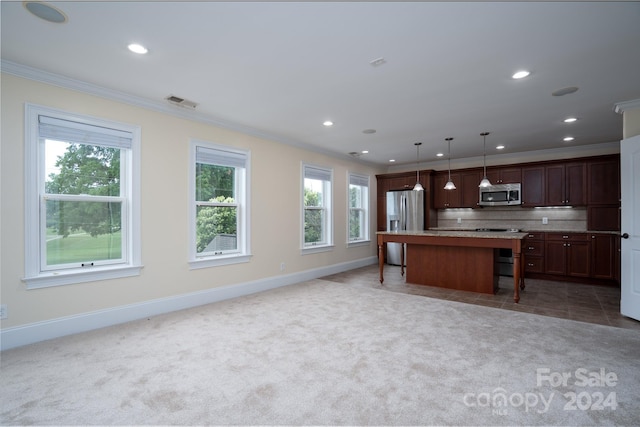 kitchen featuring hanging light fixtures, stainless steel appliances, carpet, a kitchen bar, and a kitchen island