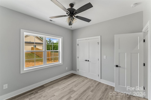 unfurnished bedroom with a closet, light hardwood / wood-style flooring, and ceiling fan