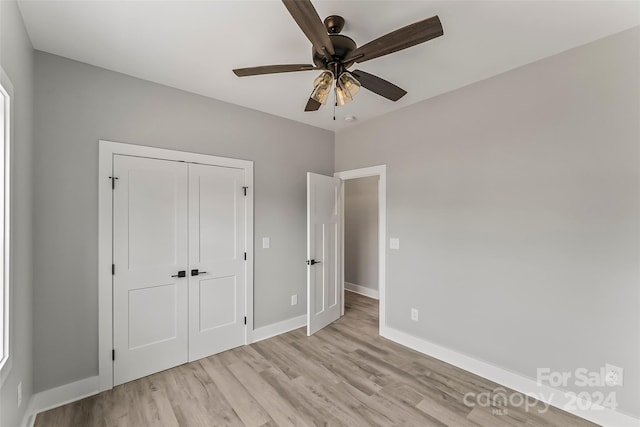 unfurnished bedroom featuring light wood-type flooring, a closet, and ceiling fan