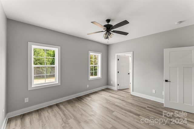 unfurnished room with ceiling fan, light wood-type flooring, and a wealth of natural light