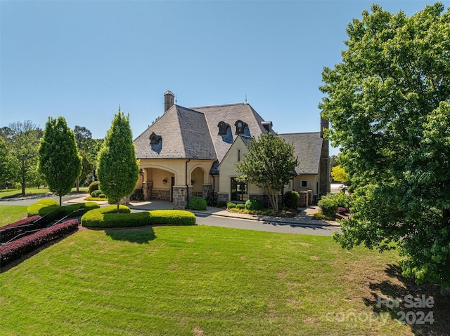 french country style house featuring a front yard