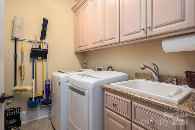 clothes washing area featuring sink, washing machine and dryer, cabinets, and tile patterned floors