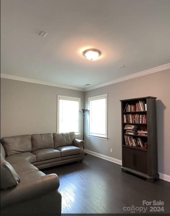 living room with dark wood-style flooring, crown molding, and baseboards
