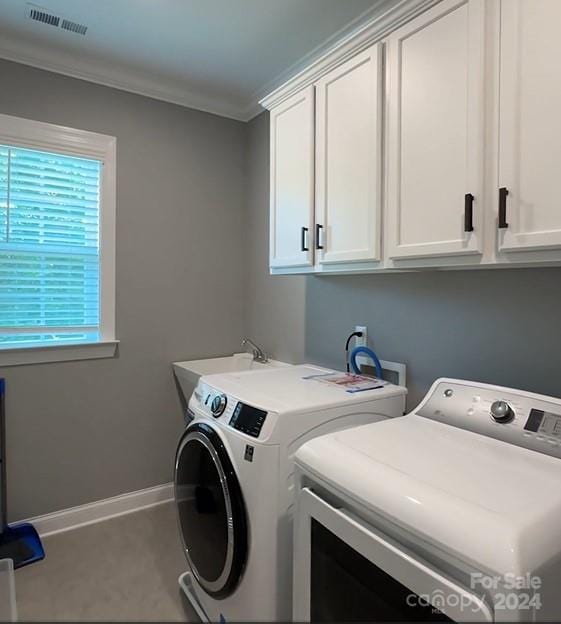 laundry area featuring separate washer and dryer, ornamental molding, and cabinets