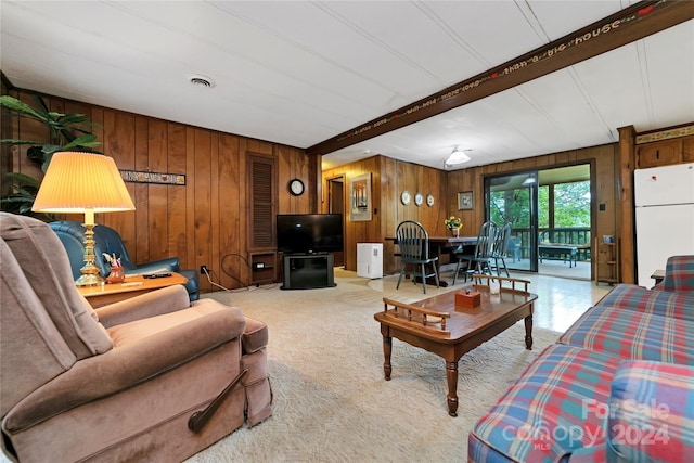 living room featuring beamed ceiling and wood walls