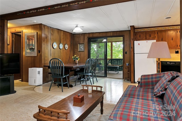 living room with beam ceiling and wood walls