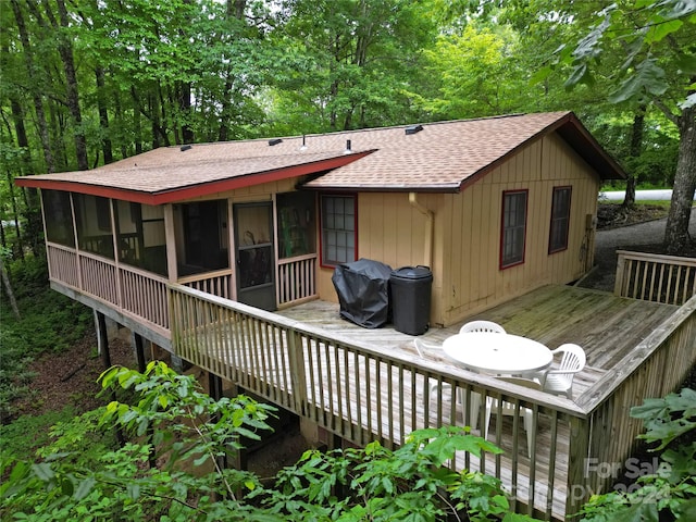 back of property featuring a deck and a sunroom