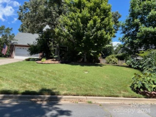 view of front of property featuring a garage and a front lawn