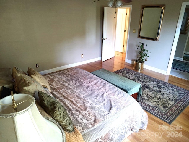 bedroom featuring ensuite bath and hardwood / wood-style flooring