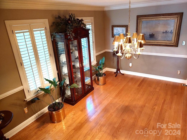 interior space with ornamental molding, hardwood / wood-style floors, and a notable chandelier