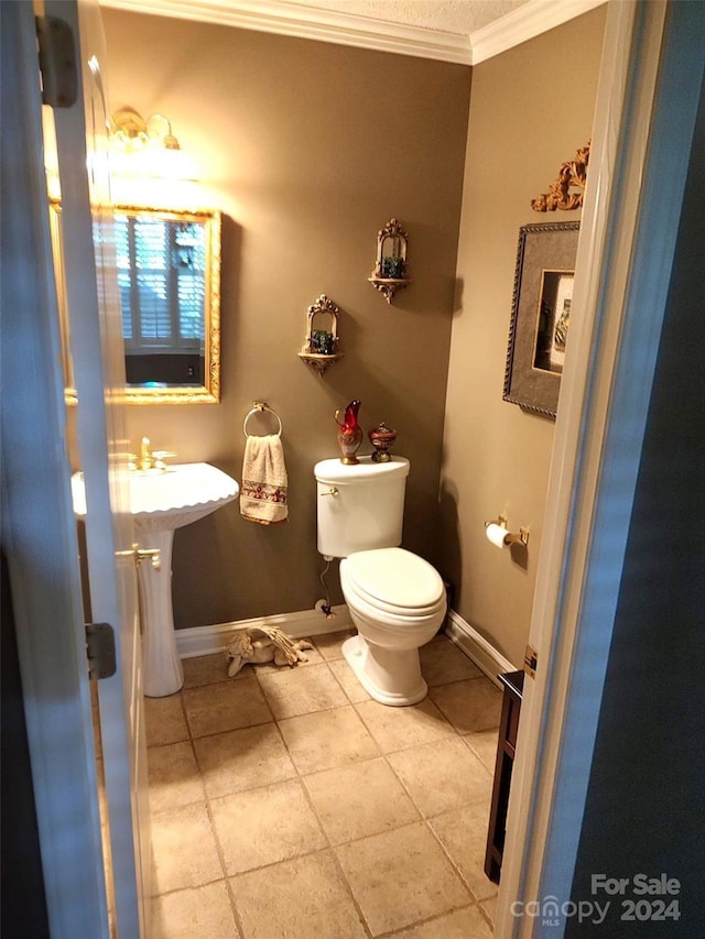 bathroom featuring toilet, ornamental molding, tile patterned floors, and sink