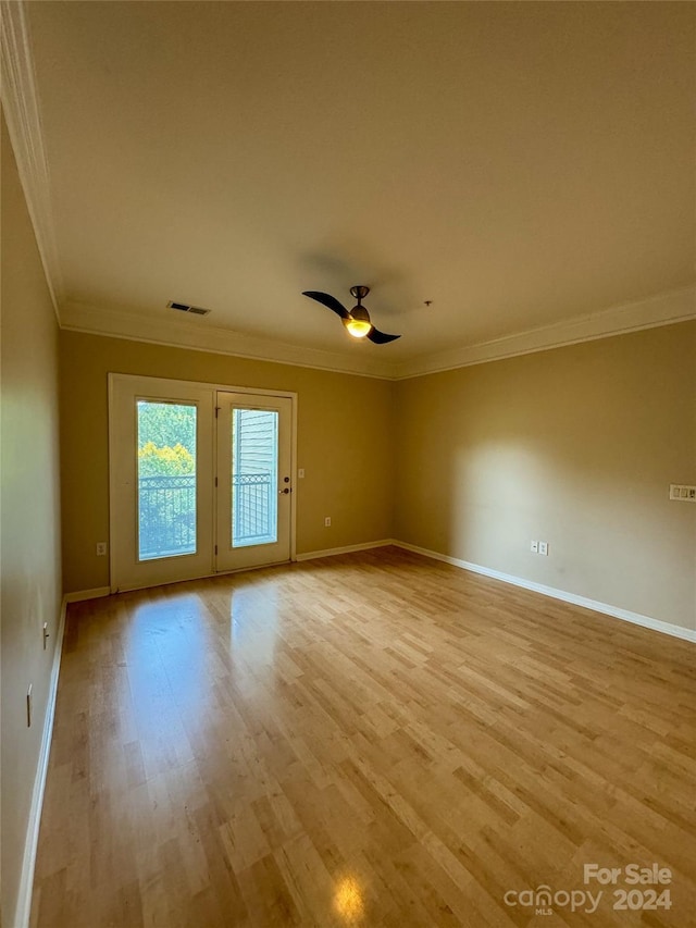 unfurnished room featuring light hardwood / wood-style floors, ornamental molding, and ceiling fan