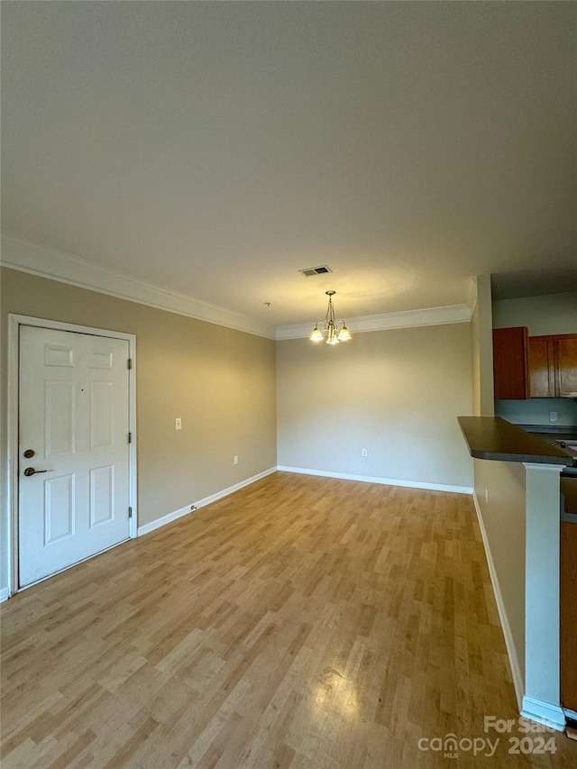 interior space featuring ornamental molding, light hardwood / wood-style floors, and a notable chandelier