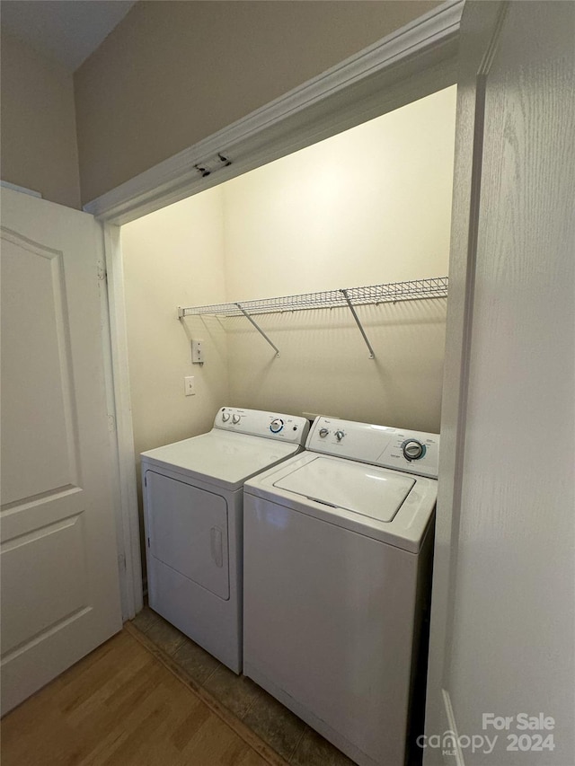 clothes washing area featuring washer and dryer and hardwood / wood-style floors