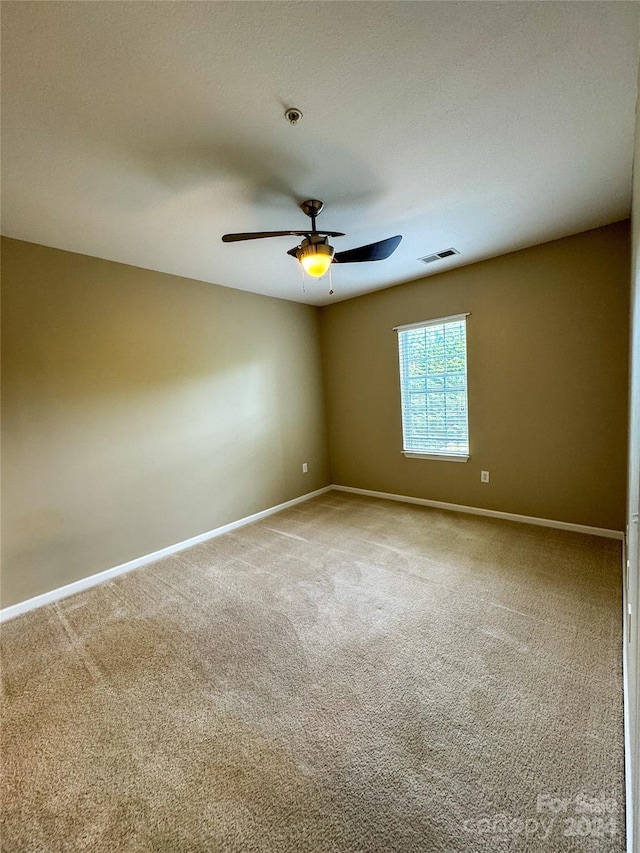 spare room featuring ceiling fan and carpet flooring