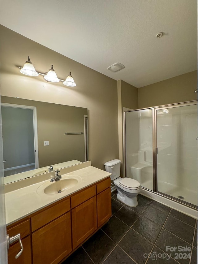 bathroom with toilet, tile patterned floors, walk in shower, and vanity