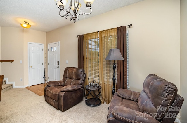 carpeted living room with a textured ceiling and a notable chandelier