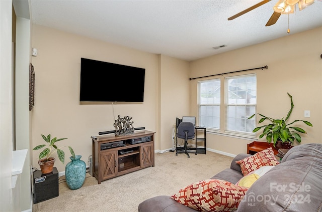 living room featuring a textured ceiling, light colored carpet, and ceiling fan