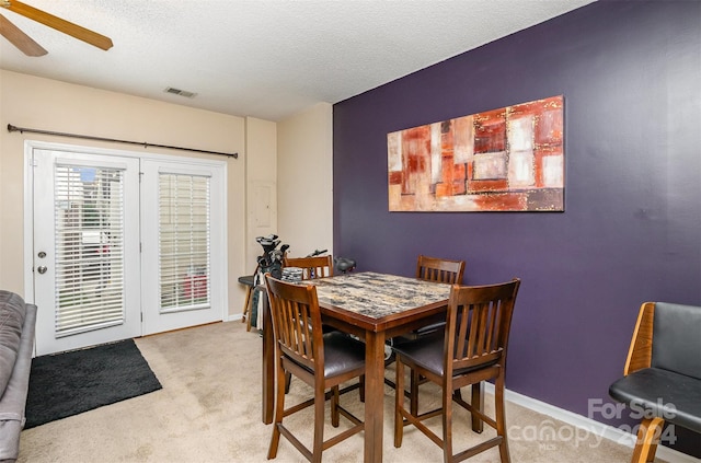 dining room featuring a textured ceiling, carpet floors, and ceiling fan