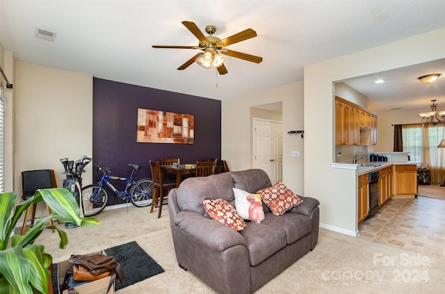 carpeted living room with ceiling fan with notable chandelier and sink