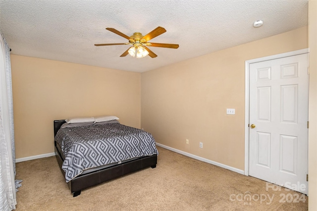 bedroom with ceiling fan, light colored carpet, and a textured ceiling