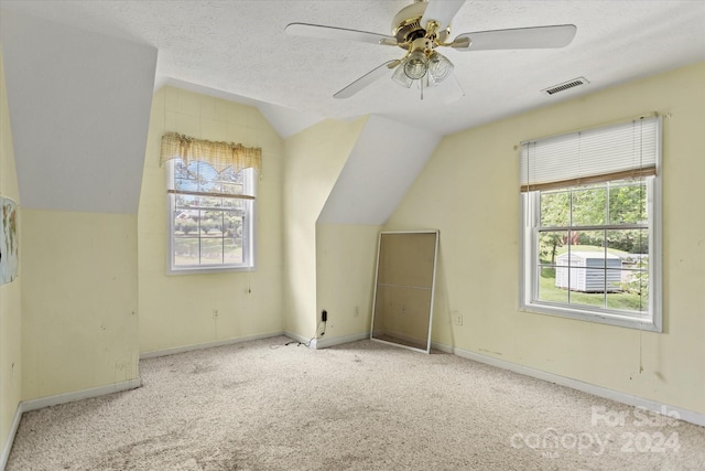 bonus room featuring vaulted ceiling, ceiling fan, a textured ceiling, and light carpet