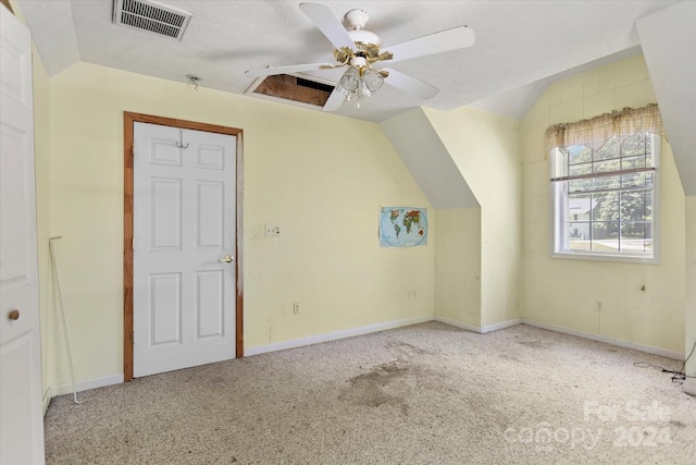 bonus room with a textured ceiling, light colored carpet, vaulted ceiling, and ceiling fan