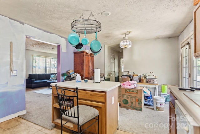 kitchen with decorative light fixtures, light carpet, and white dishwasher