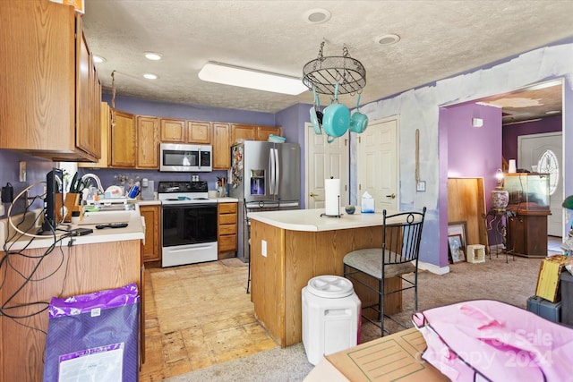 kitchen featuring sink, a kitchen island, a textured ceiling, and stainless steel appliances