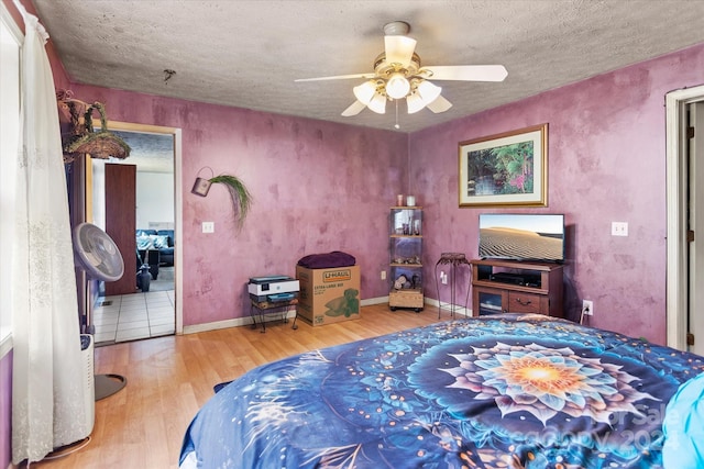 bedroom featuring wood-type flooring, a textured ceiling, and ceiling fan