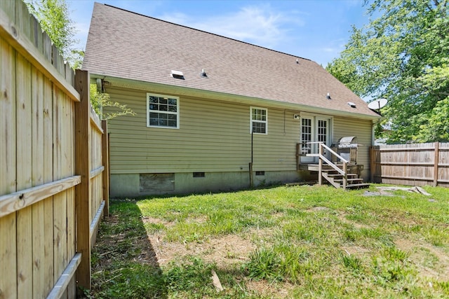 rear view of property featuring a lawn and french doors