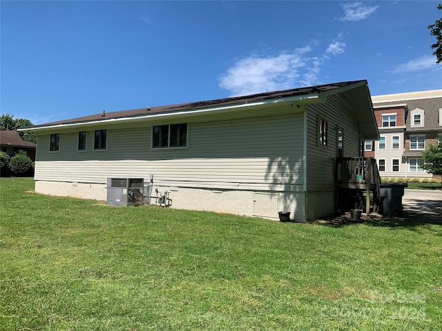 rear view of house with a lawn and cooling unit