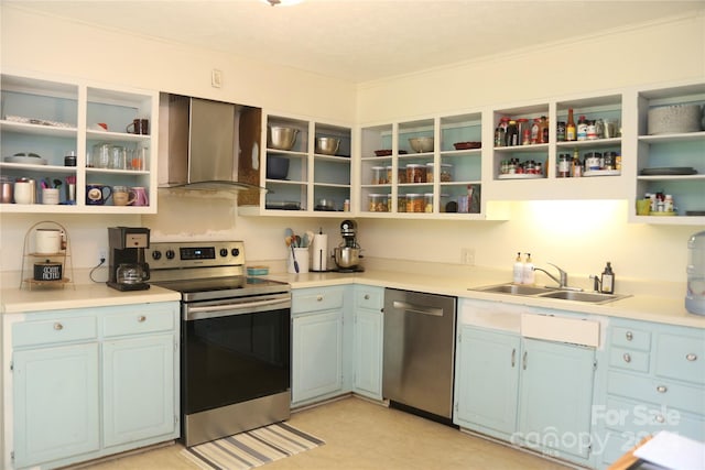 kitchen with wall chimney exhaust hood, ornamental molding, appliances with stainless steel finishes, sink, and light tile floors