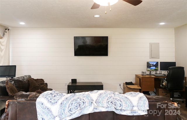 living room featuring a textured ceiling and ceiling fan